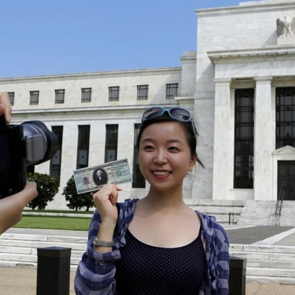 Chinese student Leyna Liu poses with a fake million dollar bill in front of the Federal Reserve building in Washington. Although the sterotypical Chinese student in the US is wealthy, most are from more modest backgrounds.Photo: Reuters