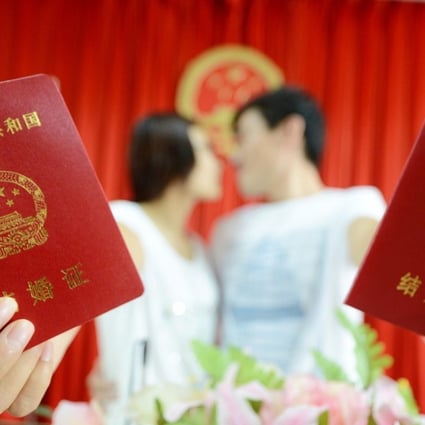 A young couple show off their marriage certificates after registering their union in Yangzhou, Jiangsu province. Photo: China Foto Press