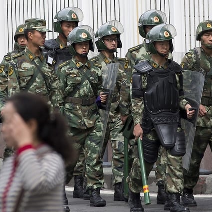 Chinese paramilitary policemen with shields and batons patrol near the People’s Square in Urumqi, China’s northwestern Xinjiang region. Photo: AP