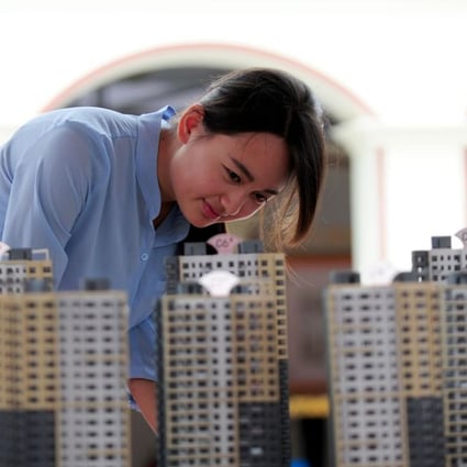 A woman looks at residential building models at a housing trade fair in Shenyang, Liaoning province. Photo: Xinhua