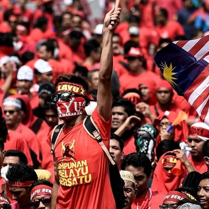 Pro-government ethnic Malay hardliners wave flags and shout slogans during a “red shirt” demonstration in Kuala Lumpur, Malaysia, on September 16. The overtly anti-Chinese rally drew concern from China’s ambassador. Photo: AFP