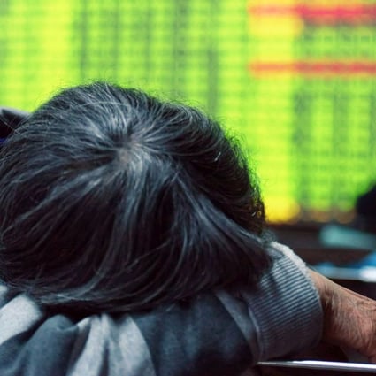An investor rests in front of a screens showing stock market movements at a securities firm in Hangzhou, Zhejiang province, on Monday. Photo: AFP