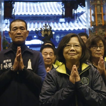 Taiwan's Democratic Progressive Party presidential candidate Tsai Ing-wen (centre) prays at a temple during a campaign stop in Beigang, Taiwan. Photo: Reuters
