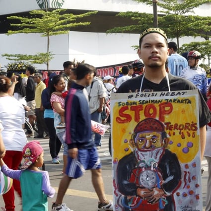 A man holds a placard that reads "Stop terrorists" in Jakarta. Photo: Reuters