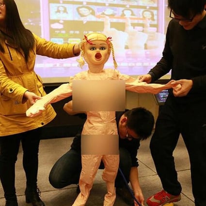 Staff at Chinese internet firm Lianlian are told how to use an inflatable sex doll, given to young men working for the company instead of a tradition cash bonus, at Sunday’s company annual conference. Photo: Guangming Daily
