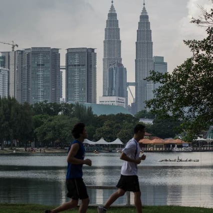 People jog in a Kuala Lumpur park across from Malaysia's landmark Petronas Twin Towers. Photo: AFP
