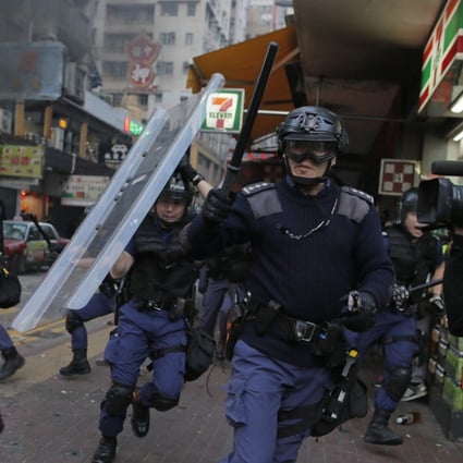 Riot police move toward protesters on a street in Mong Kok during chaotic scenes with protesters and police. Photo: AP