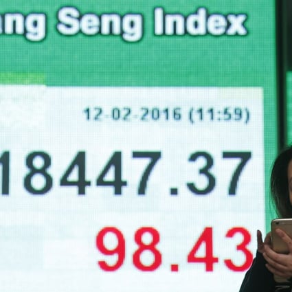 A woman uses her smartphone in front of an electronic board showing the Hong Kong index at a bank in Hong Kong last Friday as a sell-off in global markets seem to be accelerating. Photo: AP