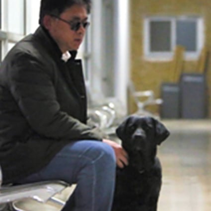 Masseur Tian Fengbo with his guide dog “Qiaoqiao”. Photo: SCMP Pictures