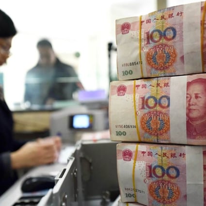 An employee counts 100-yuan notes at a bank in Lianyungang, Jiangsu province. Photo: AFP