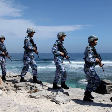 People’s Liberation Army navy personnel patrol on Woody Island, in the Paracels. The words on the rock read, “Xisha Old Dragon”. Photo: Reuters