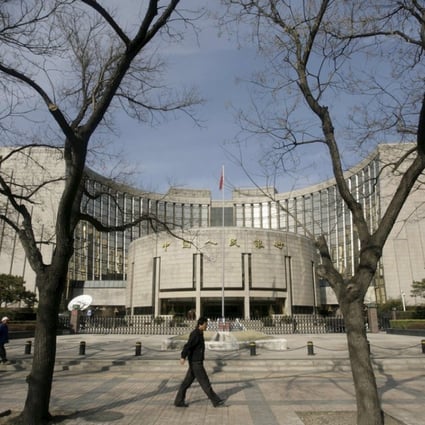 People walk past the headquarters of the People's Bank of China in Beijing. Photo: Reuters