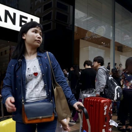 Mainland Chinese visitors wait outside a luxury store at a shopping district in Hong Kong. Photo: Reuters