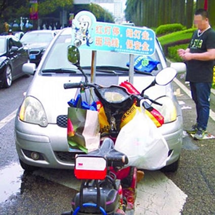 An electric bicycle is parked in front of a Toyota car in Zhangshan following the alleged revenge attack. Photo: Zhongshan Daily