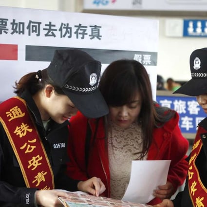 Railway police in Inner Mongolia show a passenger how to spot fake rail tickets on World Consumer Rights Day on Tuesday. Photo: Xinhua