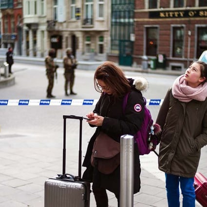 Tourists look for directions as police patrol near the European Commission after the explosion at Maelbeek Metro station. Photo: EPA