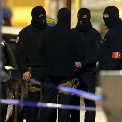 Masked Belgian police secure the entrance to a building in Schaerbeek in Brussels early on Friday. Photo: Reuters