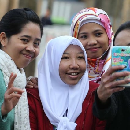 Erwiana Sulistyaningsih (white headscarf, centre), on a return visit to the city. Photo: Felix Wong