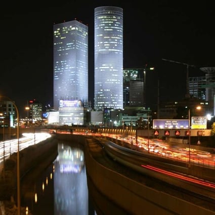 Rush hour traffic seen on the Ayalon Highway under the Azrieli Towers that dominate the Tel Aviv skyline. Photo: EPA