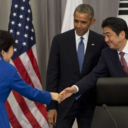 South Korean President Park Geun-hye, left, shakes hands with Japanese Prime Minister Shinzo Abe as President Barack Obama watches after their meeting at the Nuclear Security Summit in Washington, on Thursday, March 31, 2016. Photo: AP