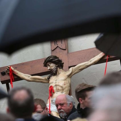 Members of the Mason's Guild in front of a figure of Jesus with red ribbons representing stigmata at a Good Friday procession through the city centre of Lohr am Main in Germany. Photo: EPA