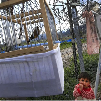 A child looks up at a bird in a cage belonging to a Syrian refugee living at a camp in Islahiye, Gaziantep province, in southeastern Turkey. Photo: AP