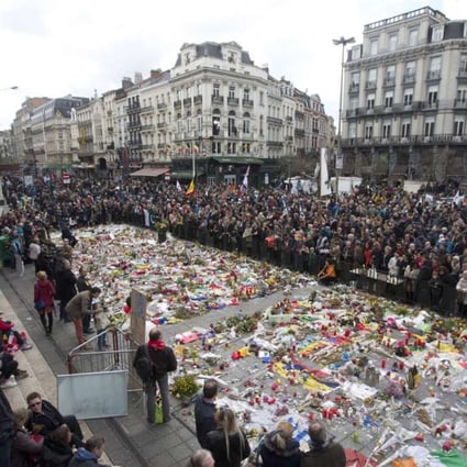 Marchers gather a floral memorial to victims of the Brussels attacks during a march against hate in Brussels on Sunday. Photo: AP