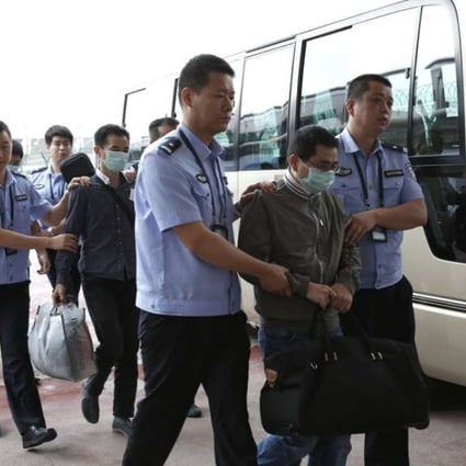 Fugitives allegedly involved in economic crimes are escorted at Beijing Capital International Airport in June 2015. Photo: Xinhua