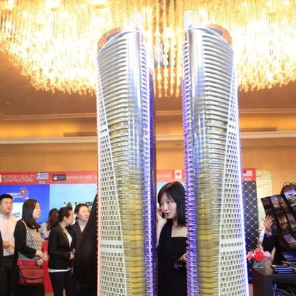 Visitors look at a luxury property model on display during the Luxury Property Showcase in Beijing on April 22, 2016. Photo: EPA