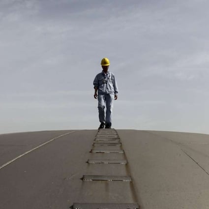 An employee walks on top of an oil tank in Wuhan, Hubei province. Photo: Reuters