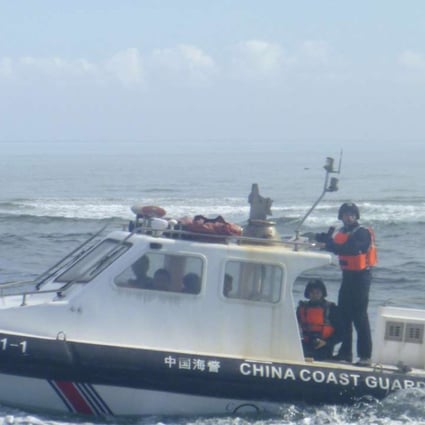 A Chinese coastguard boat approaches Filipino fishermen near Scarborough Shoal in the South China Sea last year. Photo: AP