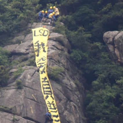 Firemen approaching the yellow banner with the words reading: "I want genuine universal suffrage" in Chinese which been put up at Beacon Hill this morning. 17MAY16 SCMP/ Sam Tsang