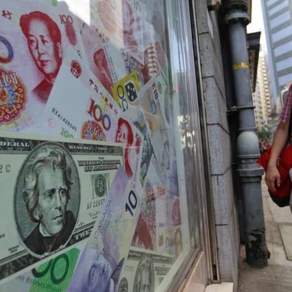 A man walks past a display of oversized banknotes outside a foreign exchange office in Hong Kong. Photo: EPA