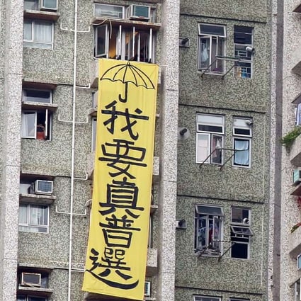 A large yellow banner draped outside a residential building next to an elderly home in Tseung Kwan O visited by Zhang Dejiang on Thursday. Photo: Nora Tam
