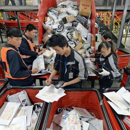 Workers sort out parcels at a distribution centre of SF Express in Wuhan city, central China's Hubei province on November. 4, 2014. Photo: Imaginechina
