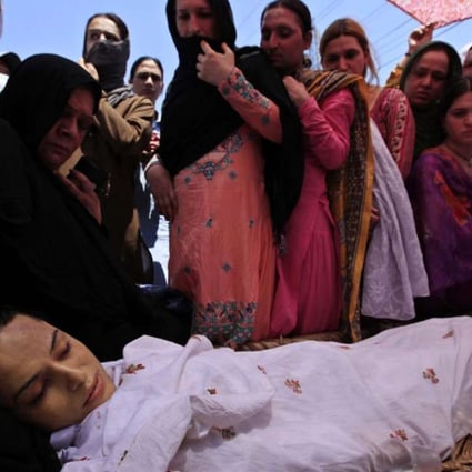 Mourners stand beside the body of transgender activist Alisha at her funeral in in Peshawar, Pakistan, on Thursday. Photo: EPA