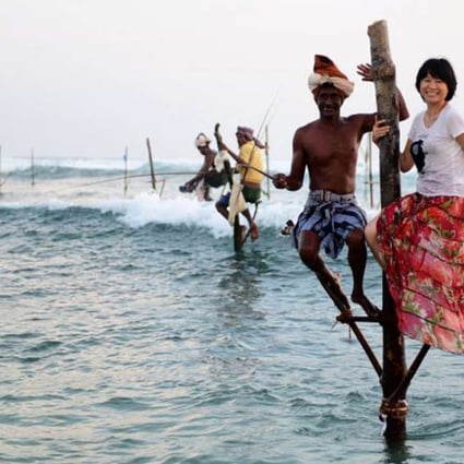 A Chinese tourist poses for a photo with a fisherman in Sri Lanka. Photo: Xinhua
