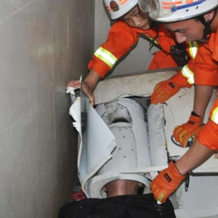 Firefighters work to free the man in Fujian province. Photo: Inews.qq.com