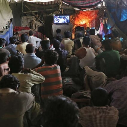 People watch a film in the makeshift cinema under a bridge in the old quarter of Delhi. Photos: Reuters