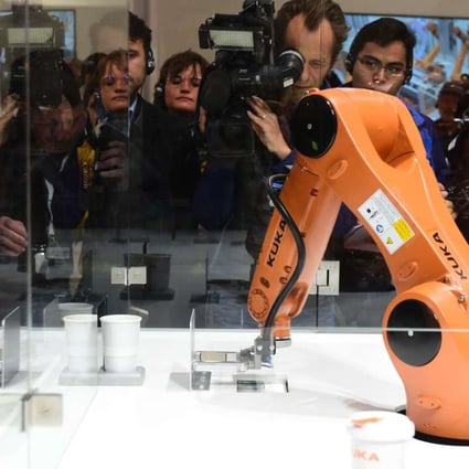 A robot prepares a cup of coffee at the booth of robotics manufacturer Kuka, on the eve of the opening of the Hanover Fair earlier this year. Photo: AFP