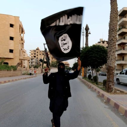 In this June 2014 file photo, a member loyal to Islamic State waves a flag in Raqqa in Syria. Photo: Reuters