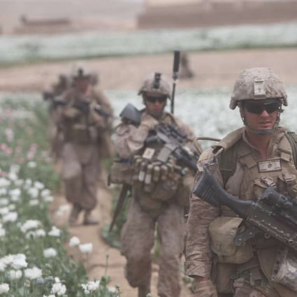 US soldiers patrolling a poppy field in Afghanistan. Intoxication and war have been intimately linked since the dawn of history.