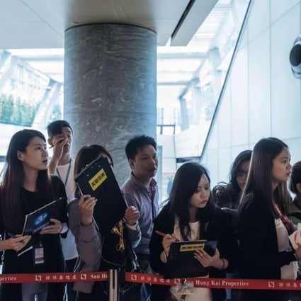 Real estate agents waiting last weekend for potential buyers outside the sales office of Park Yoho Venezia, a residential property developed by Sun Hung Kai Properties Ltd in Hong Kong. Anthony Kwan, Bloomberg