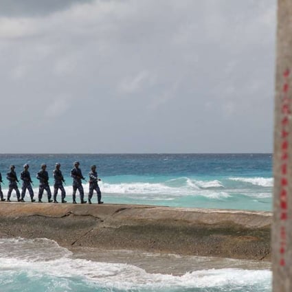 People's Liberation Army Navy soldiers patrol near a sign in the Spratly Islands reading ‘Nansha is our national land, sacred and inviolable’. Photo: Reuters