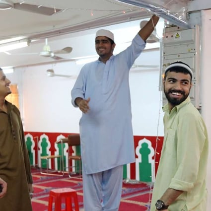 Muslims share a light moment as they decorate the Idara Minhaj-ul-Quran mosque in Kwai Chung in preparation for celebrations of the end of Ramadan. Photo: Bruce Yan