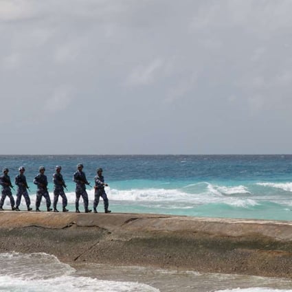 Soldiers of the People’s Liberation Army Navy patrol near a sign on the Spratly Islands, known in China as the Nansha Islands. The sign reads “Nansha is our national land, sacred and inviolable”. Photo: Reuters