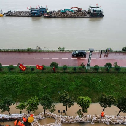 Workers reinforce a temporary dyke at Shuren Middle School in Nanjing, Jiangsu Province. A section of the Yangtze River embankment near the school continued to leak on Monday morning so the temporary dyke was built. Photo: Xinhua