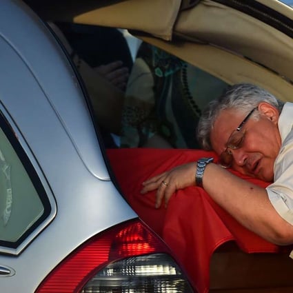 The father of Simona Monti, one of the nine Italians killed in the Bangladesh attack, mourns on her coffin near Rome. Photo: AFP
