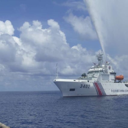 A Chinese coastguard vessel trains its hoses on Filipino fishermen off Scarborough Shoal in the South China Sea in September last year. Photo: AP