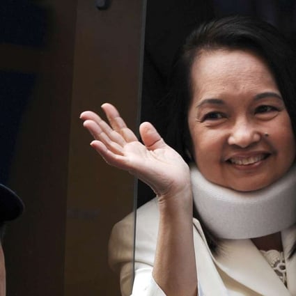 Former Philippine president Gloria Arroyo waves to photographers from a vehicle after appearing in court in 2012. File photo: AFP